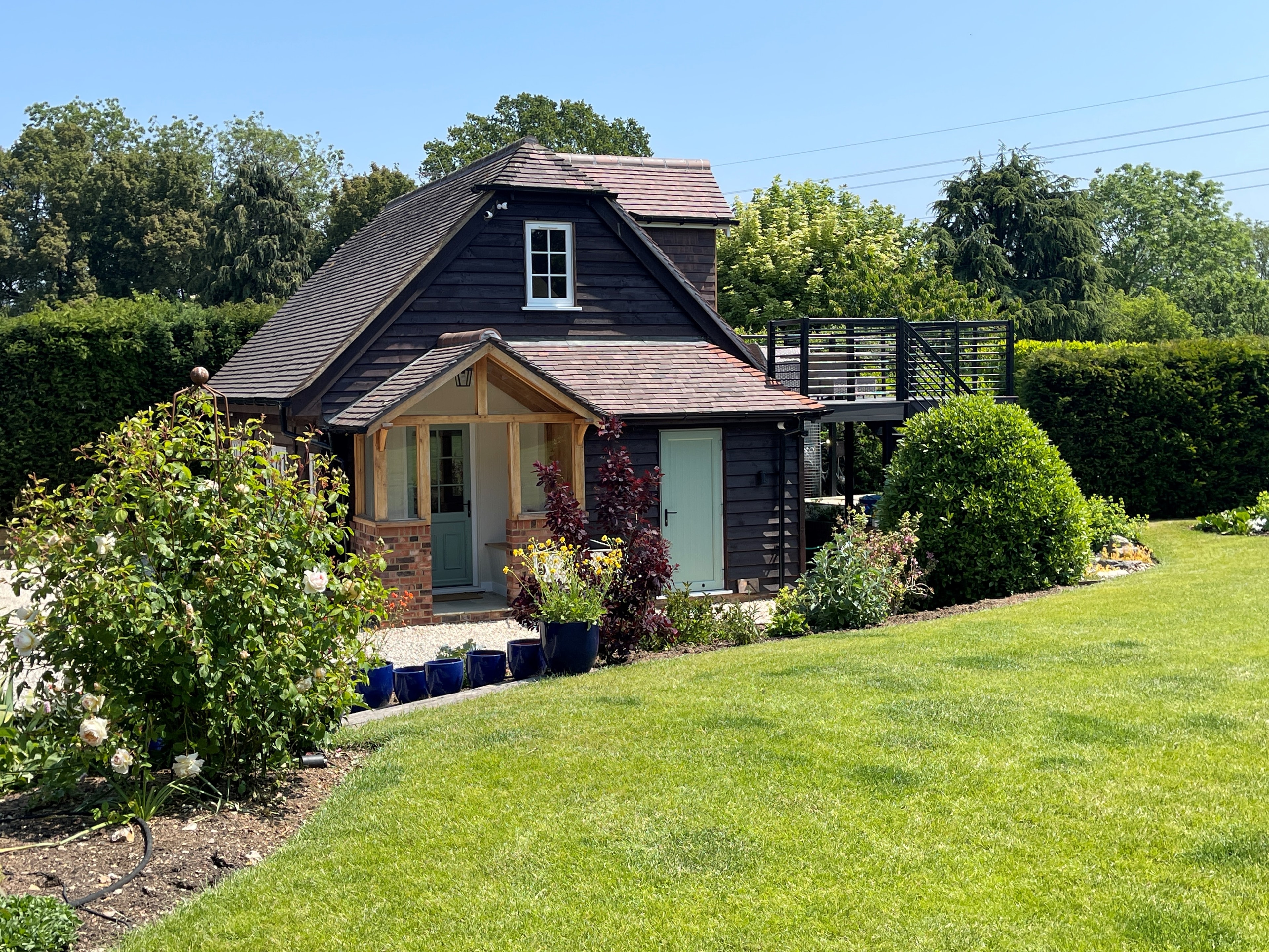 Neatham Barn beside its garden in daylight